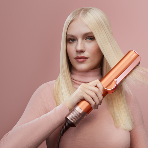 femeie blonda folosind dyson airstrait ceramic apricot